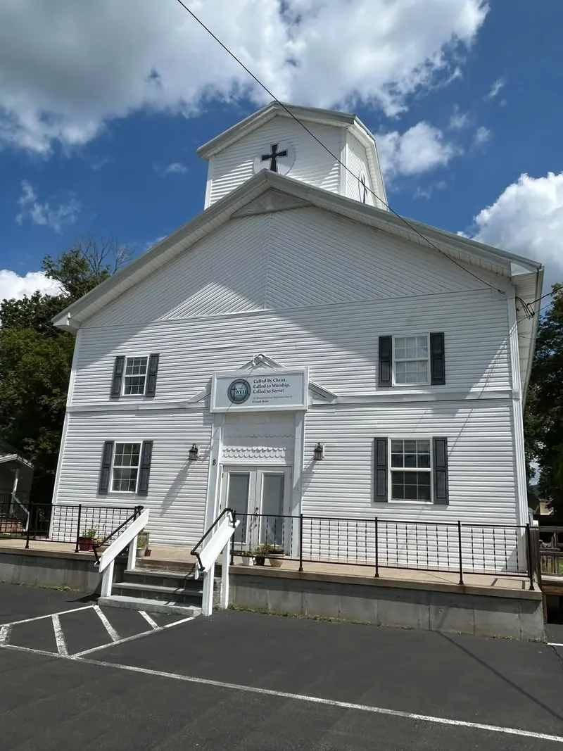 The front of The Well EPC at 8 Canal St in Big Flats, with its cross, welcome sign, and front steps